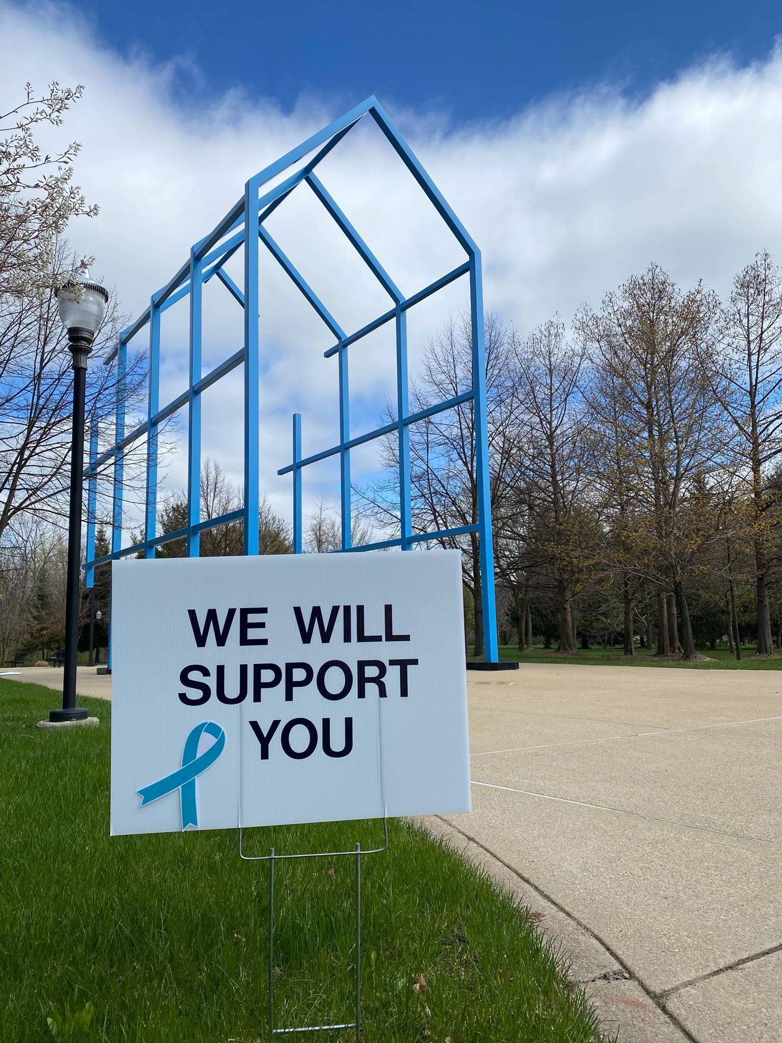Sign in front of Transitional Link reads "We Will Support You" with a teal ribbon